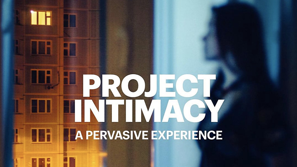 Project Intimacy, a pervasive experience: a woman at a window at night, a lit tower block opposite